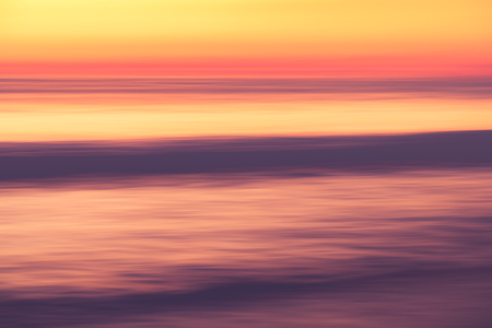 Motion blur tropical sunset beach with bokeh light wave abstract background. Copy space of summer vacation and business travel adventure concept. Vintage tone filter effect color style.の写真素材