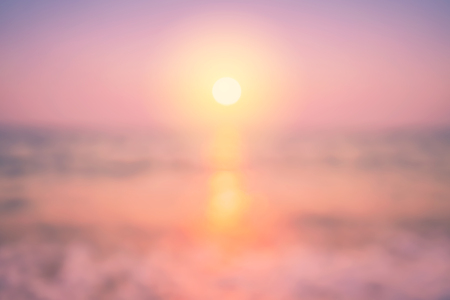 Blur tropical sunset beach with bokeh sun light wave abstract background. Copy space of outdoor summer vacation and travel adventure concept. Vintage tone filter color style.の写真素材