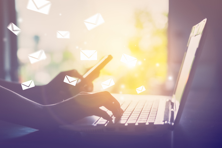 woman hand using laptop with email icon flying backgroundの写真素材