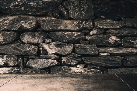 Dark room stone brick wall texture background. Copy space for product presentation and graphic design.の写真素材