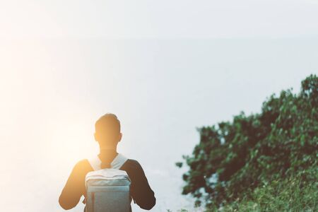 Copy space of backpack man looking view of beach with blue sky background. Freedom and travel adventure concept. Vintage tone filter effect color style.の写真素材