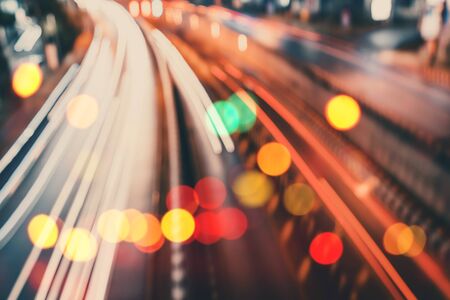 Motion blur traffic road with colorful bokeh light and old building town abstract background. Copy...