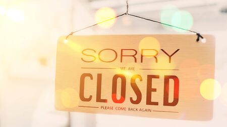 Closed sign hanging front of cafe mirror door. Business service and food drink concept. Vintage tone filter effect color style.の写真素材