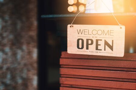 Open sign broad hanging on wood door front of cafe. Business service and food concept. Vintage tone filter effect color style.の写真素材