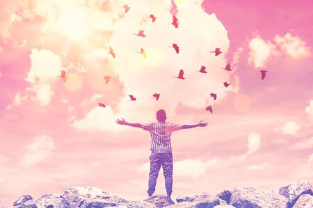Freedom feel good and travel adventure concept. Copy space of silhouette man rising hands on sunset sky double exposure colorful bokeh and bird fly background. Vintage tone filter effect color style.の写真素材