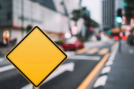 Empty yellow traffic sign on blur traffic road with colorful bokeh light abstract background. Copy space of transportation and travel concept. Retro tone filter color style.の写真素材