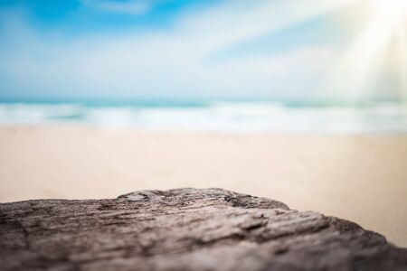 Blur tropical beach with bokeh sun light wave on empty old nature wood table abstract background. Product presentation in nature. Vintage tone filter color style.の写真素材