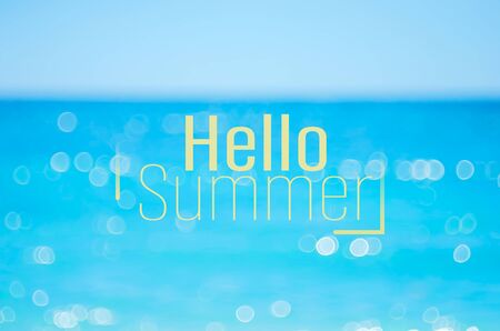 Hello summer words on blur tropical beach with bokeh sunlight wave abstract background. Summer vacation and travel holiday concept. Vintage tone filter effect color style.の写真素材