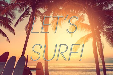 Let's surf words on surfboard and palm tree on tropical sunset beach abstract background. Summer...