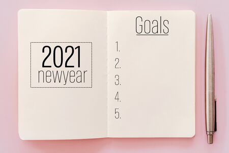 2021 new year goals on notebook with pencil. Pastel color background.の写真素材
