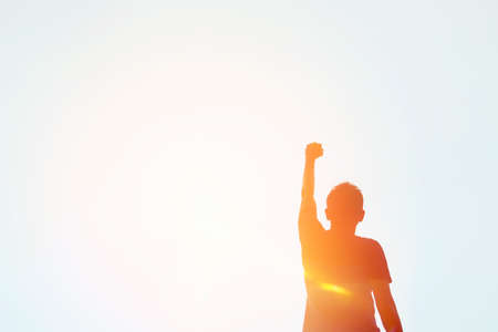 Copy space of man hand raising on top of mountain and sunset sky abstract background. Freedom travel adventure and business victory concept. Vintage tone filter effect color style.の写真素材