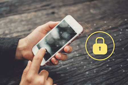 Woman hand using smart phone with lock icon graphic at coffee shop. Technology business concept....