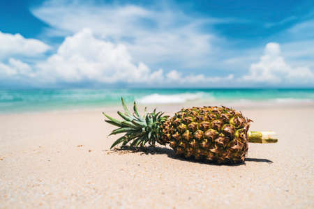 Pineapple on tropical beach background. Summer vacation and healthy food concept.