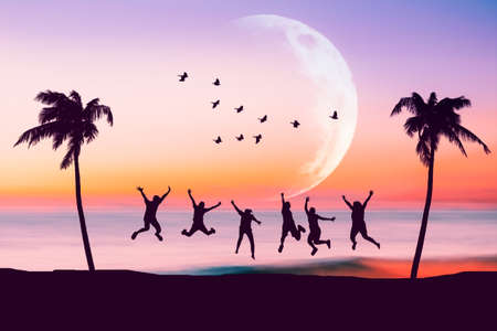 Silhouette happy friends jumping on sunset sky at tropical beach with palm tree and birds flying full moon abstract background. Feel good freedom and travel adventure concept. Vintage tone color.の写真素材