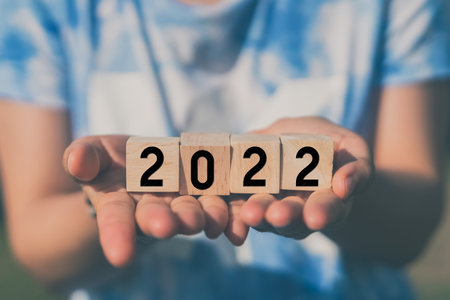 Woman holding wood cube with number 2022. Happy new year and holiday concept. Vintage tone filter effect color style.の写真素材