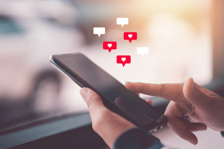 Woman hand using smartphone with heart icon at coffee shop background. Technology business and...