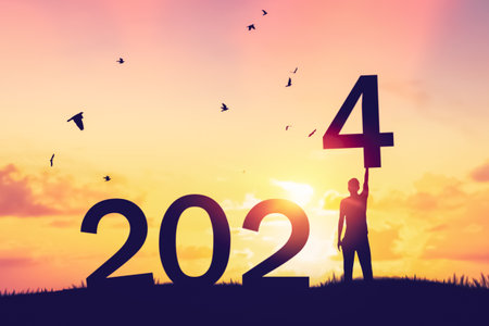 Man raise hand up on sunset sky with birds flying at top of mountain and number like 2024 abstract background. Happy new year and holiday concept. Vintage tone filter effect color style.の写真素材