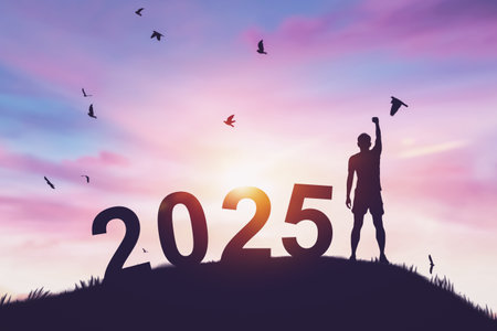 Man raise hand up on sunset sky with birds flying at top of mountain and number 2025 abstract background. Happy new year and holiday concept.の写真素材