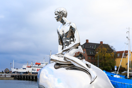 HELSINGOR (Elsinore), DENMARK - 2016 OCTOBER 19: Sculpture "Han" (art. Michael Elmgrin and Ingar Dragset). The sculpture mirror repeats the pose of the Mermaid, but on the stone sits a naked young man.のeditorial素材