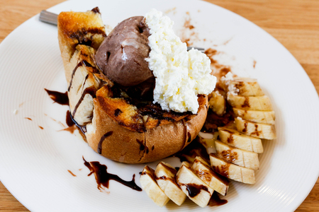 Ice cream honey toast and banana on wood table.の写真素材