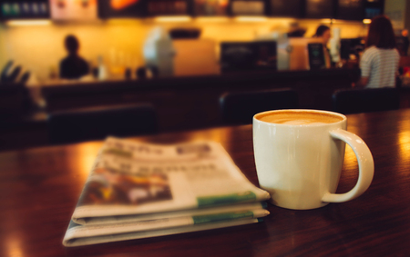 Latte coffee on coffee shop with heart pattern in a white cup on wooden table in cafe backgroundの写真素材