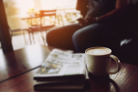 Latte coffee on coffee shop with heart pattern in a white cup on wooden table in cafe backgroundの写真素材