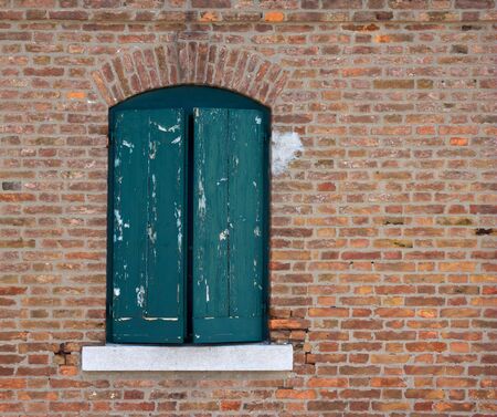 Old window in weathered brick wallの写真素材