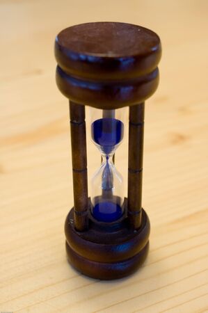 A hourglass on wooden tableの写真素材