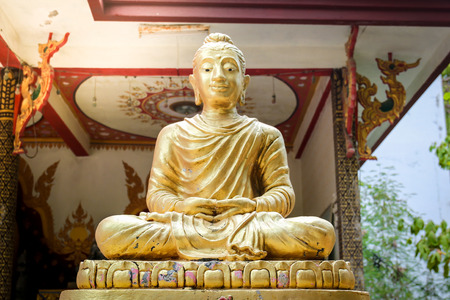 Statue of Buddha sitting meditating Mahayana gold on the outdoor platform.