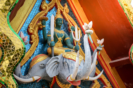 Indra statue carries two elephants holding a weapon using a trumpet holding a lotus on a temple roof.の写真素材