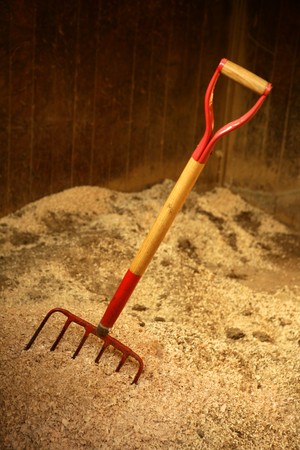 Horse stable witth straw fork tool, sawdust.の写真素材