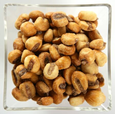 Roastwed salted corn in a transparent glass bowl, white background studio shoot