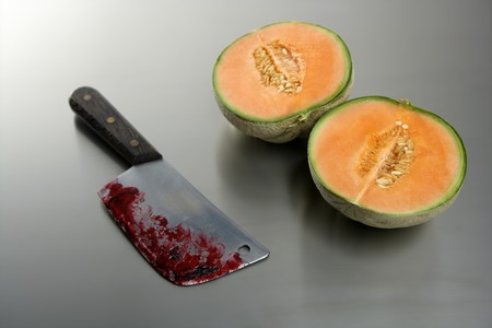 Metaphor of a bloody knife after killing a melon fruitの写真素材