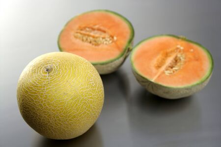 Two melon fruit over a stainless steel tableの写真素材
