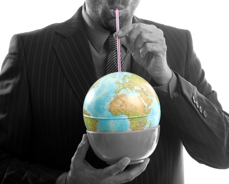 Businessman drinking the world, a power leader metaphorの写真素材