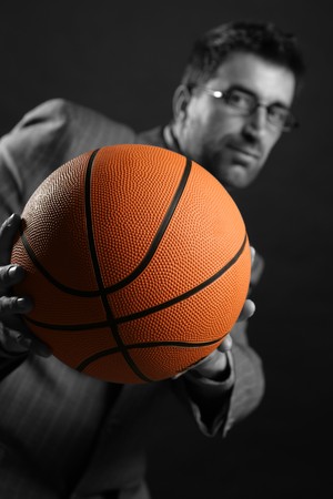 Businessman with basketball ball, teamwork, leadership metaphorの写真素材