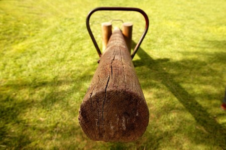 old wooden balance teeter totter in the park, grass backgroundの写真素材