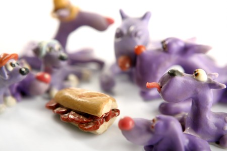 Handmade hungry plasticine dogs withy some meat to eatの写真素材
