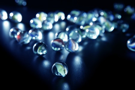 glass marbles with blue reflections over black backgroundの写真素材