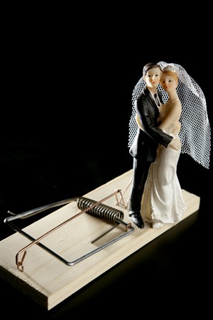 Marriage seen as a mouse trap classic male idea isolated over blackの写真素材