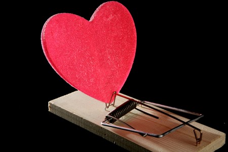 Love and health as a mouse trap. Metaphor with red candy heartの写真素材