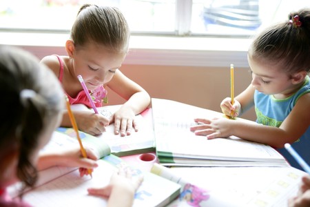 Beautiful little girls doing school homework at homeの写真素材