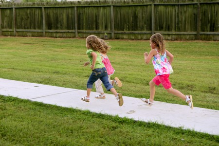 Three sister girls playing running on the green park outdoorの写真素材