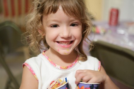 Sweet little girl smiling to camera, indoors at homeの写真素材