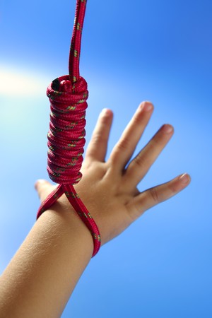 Children hand hanged on red thread, hangman knot, education metaphorの写真素材