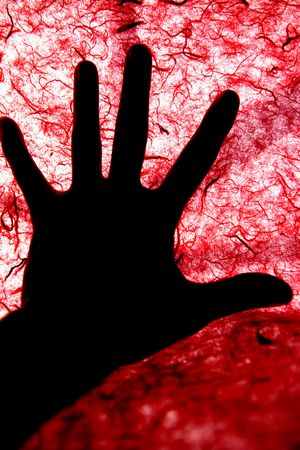 Backlight of human hand over red textured surface, bloodyの写真素材