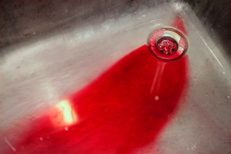 Blood in vivid red in a stainless steel sink, murder metaphorの写真素材