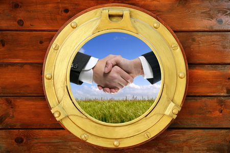 Businessmen green outdoor handshake view from boat round windowの写真素材
