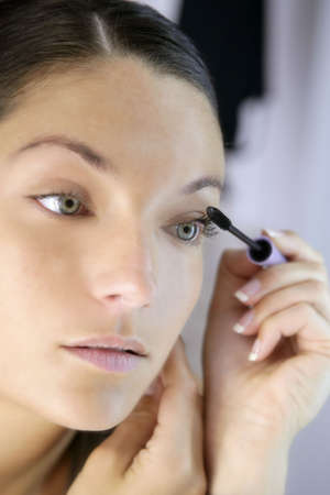 Beautiful woman portrait on the mirror with eye self makeup