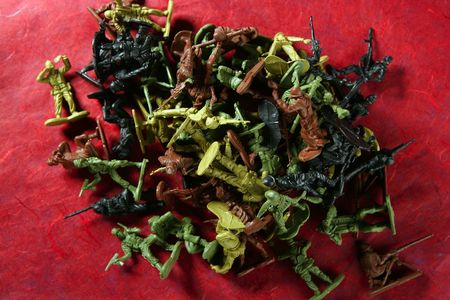 Metaphor of dead plastic toy war soldiers on a red bloody backgroundの写真素材